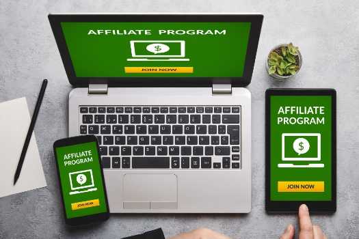 a laptop, a tablet and a smartphone with affiliate program written on their screens along with a dollar icon and a button that says JOIN NOW